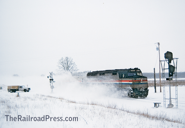 Amtrak F40PH #212 with a passenger train rushing through the snow in southwest Michigan
