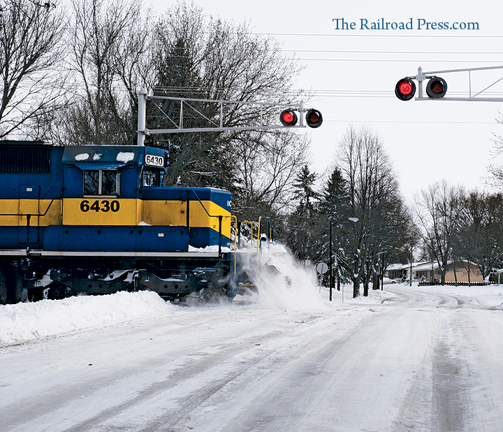 Iowa, Chicago & Eastern SD40-2 #6430 plows through a snowpile at a grade crossing in South Dakota