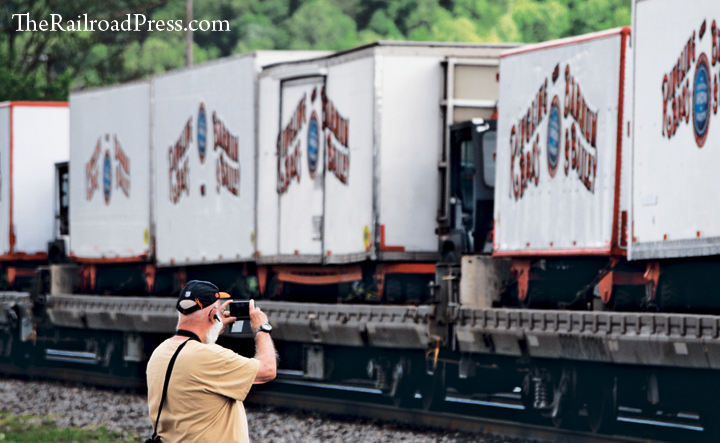 A man photographs the flatcars loaded with circus wagons on the Ringling Brothers and Barnum & Bailey circus train at Dickinson (Belle), West Virginia, on WATCO's Kanawha River Railroad
