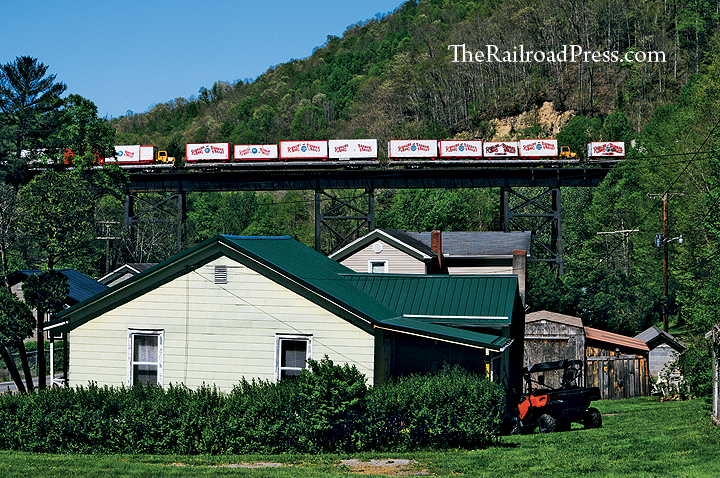 Flatcars loaded with containers and circus wagons on the Ringling Brothers and Barnum & Bailey circus train are rolling across the trestle at Slab Fork, West Virginia, on WATCO's Kanawha River Railroad